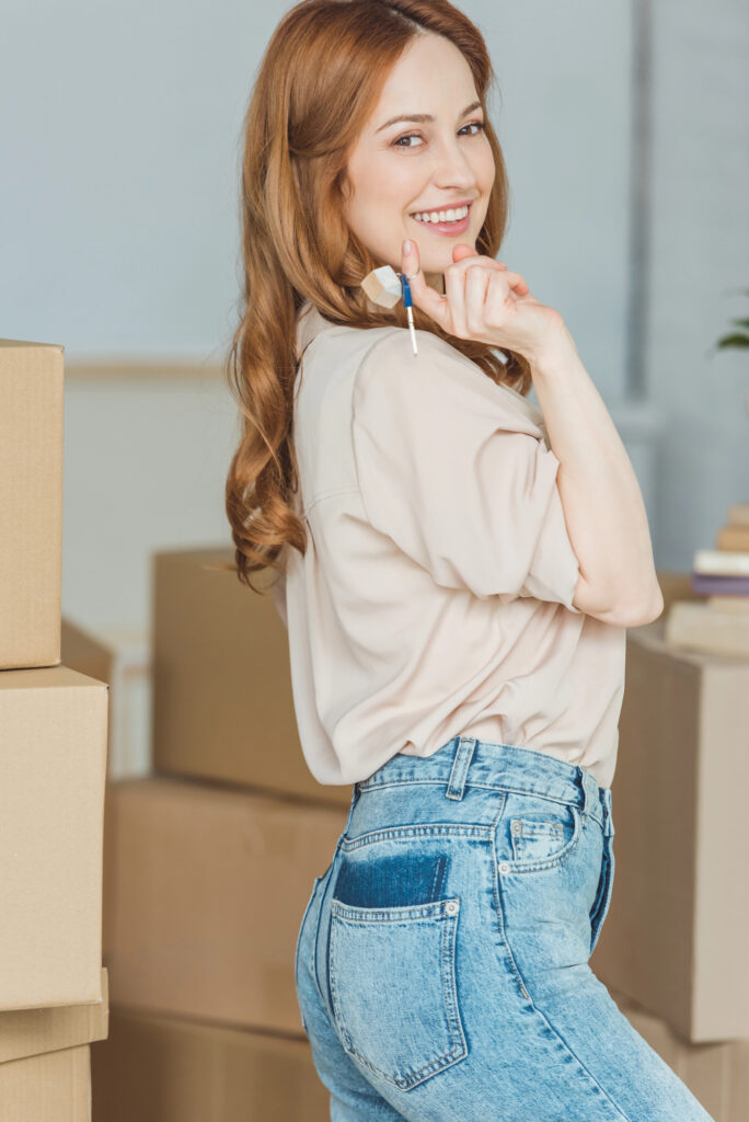 young woman with keys to her first house she owns
